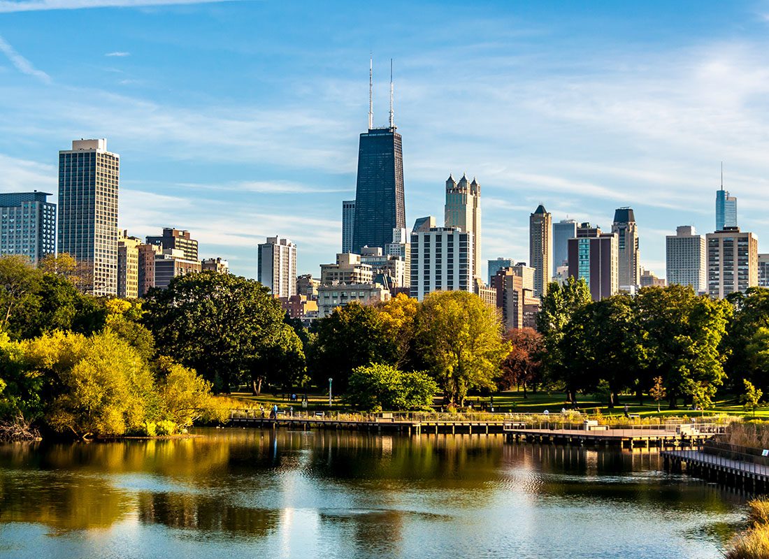 Chicago, IL - View of Downtown Chicago Illinois Skyline with Skyscrapers Behind Colorful Trees Surrounding a Lake