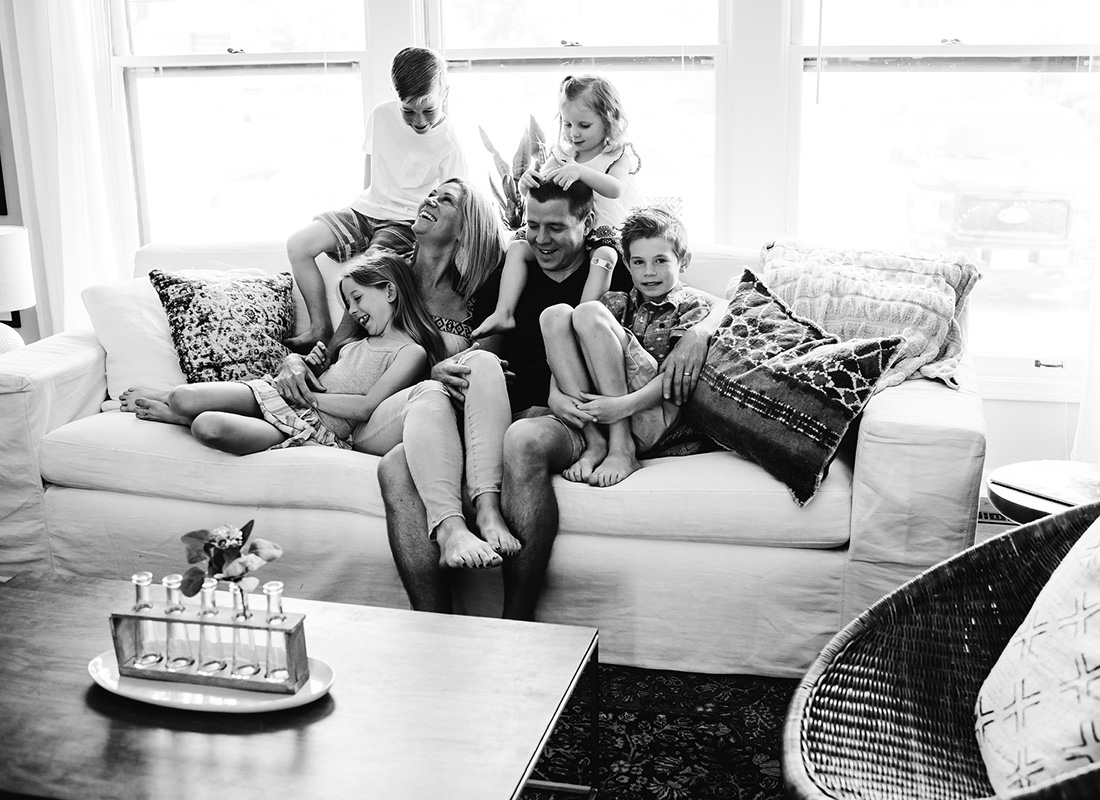 Meet Our Team - Portrait of Agency Owner Brendan Smith Having Fun Sitting on the Sofa at Home with his Wife and Four Children