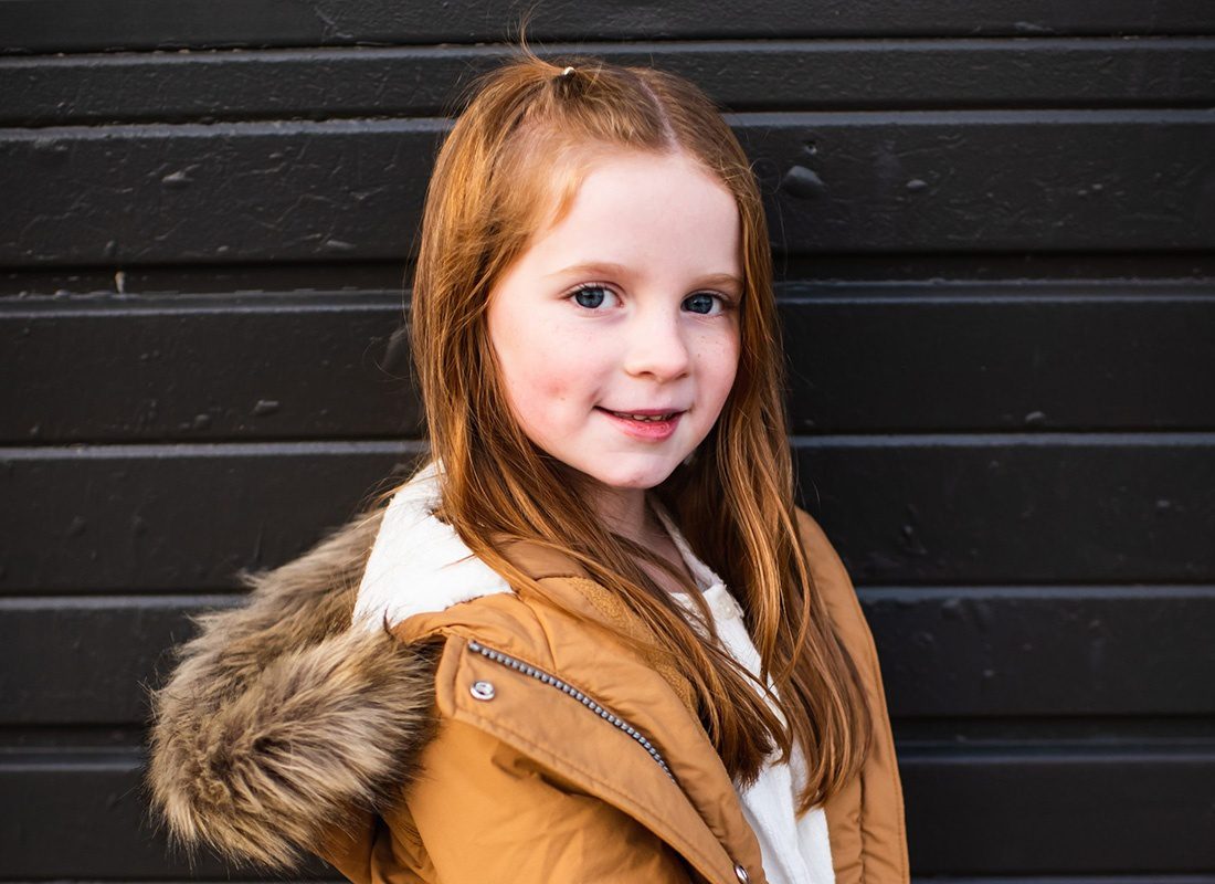 Meet Our Team - Smiling Portrait of Brendan Smith's Youngest Daughter Wearing a Winter Coat